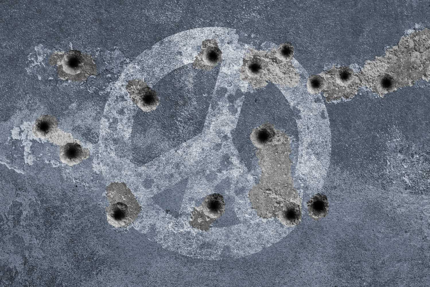 Peace symbol on a wall with bullet holes. Photo: Getty Images