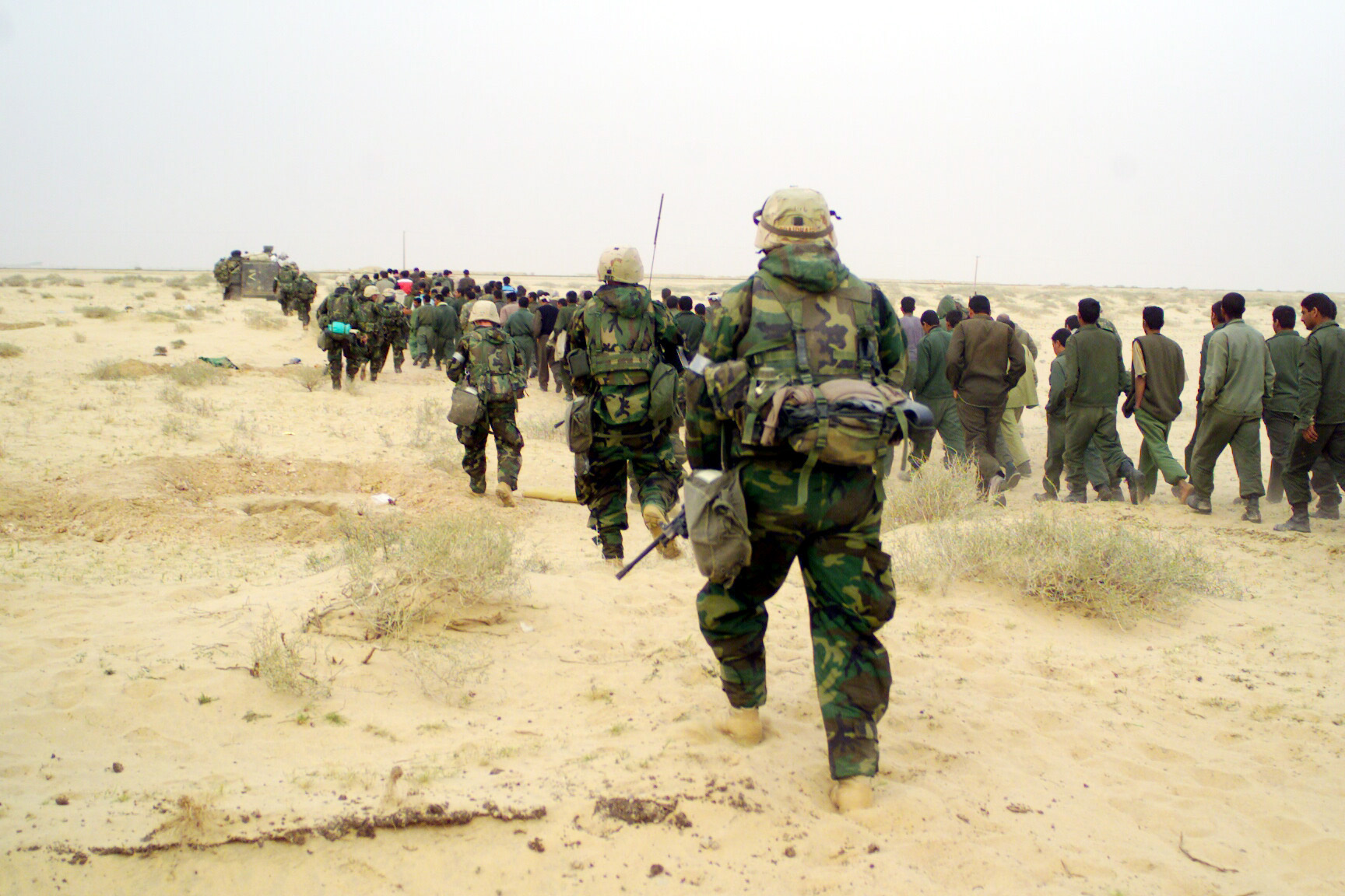 030321-M-3692W-053
U.S. Marines from the 2nd Battalion, 1st Marine Regiment escort captured enemy prisoners of war to a holding area in the desert of Iraq on March 21, 2003, during Operation Iraqi Freedom.  Operation Iraqi Freedom is the multinational coalition effort to liberate the Iraqi people, eliminate Iraq's weapons of mass destruction and end the regime of Saddam Hussein.  DoD photo by Lance Cpl. Brian L. Wickliffe, U.S. Marine Corps. Photo: LCPL BL WICKLIFFE