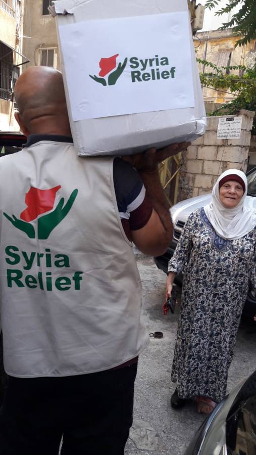 A Syria Relief aid worker carrying an emergency foodpack to a survivor of the Beirut explosion in August 2020. Edwardtheeduard / Wikimedia Commons