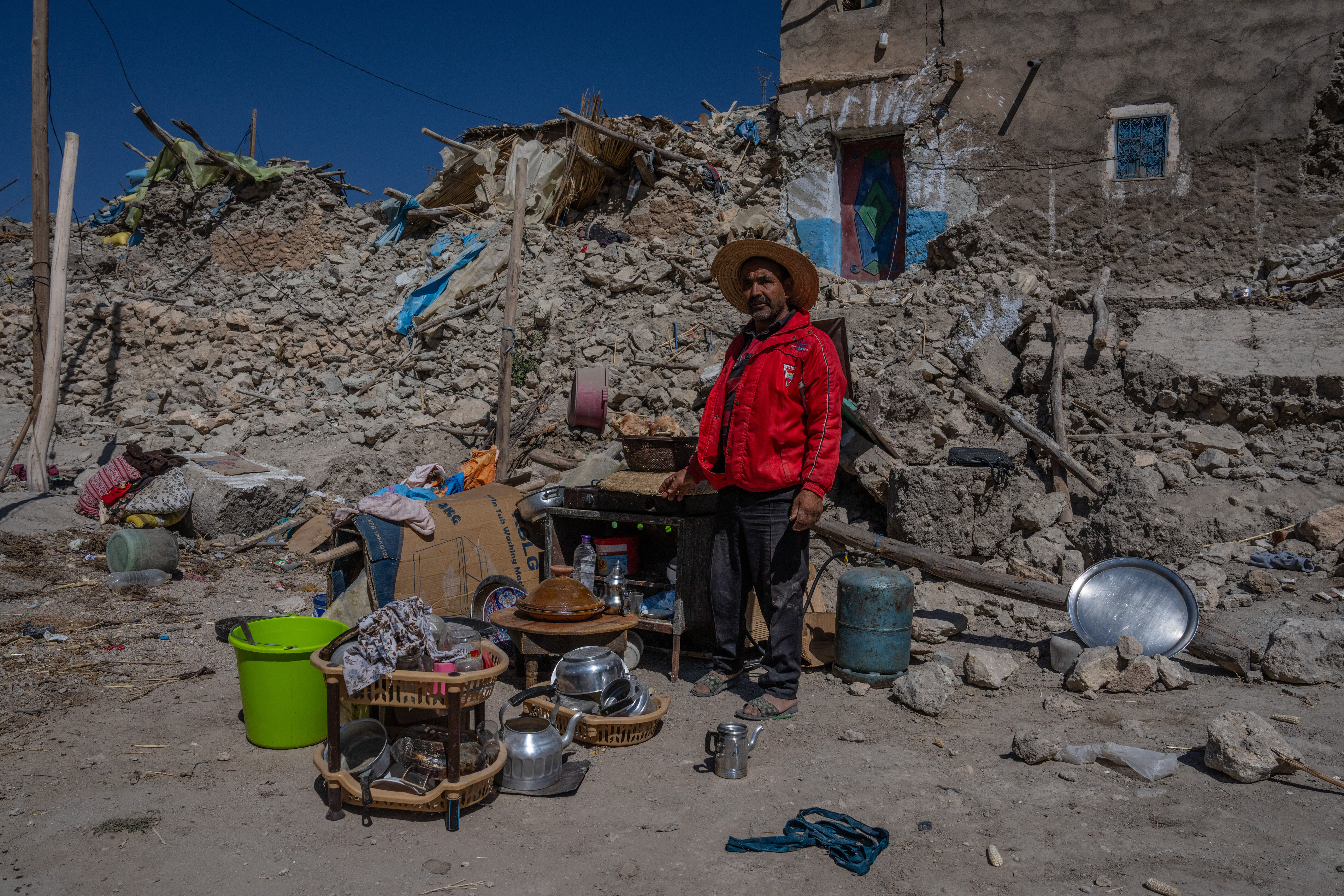 A man stands next to goods he has salvaged from the ruins of his house on September 13, 2023 in Ardouz, Morocco. Photo: Carl Court/Getty Images