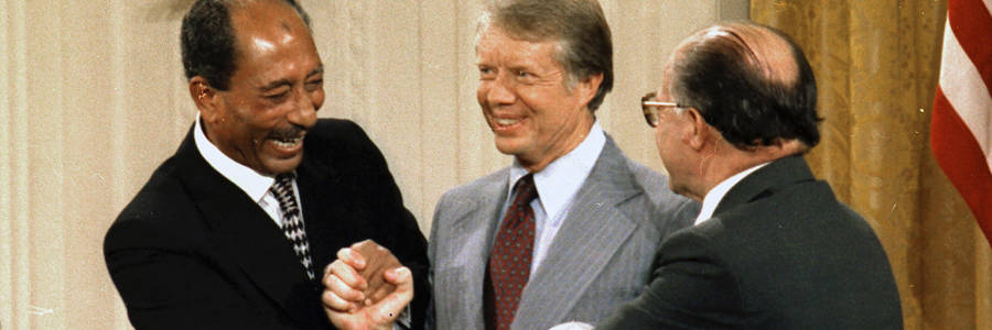 Egyptian President Anwar Sadat, U.S. President Jimmy Carter, and Israeli Prime Minister Menachem Begin shake hands at the conclusion of the Camp David Peace Accords signing ceremony. US National Archives and Records Administration CC