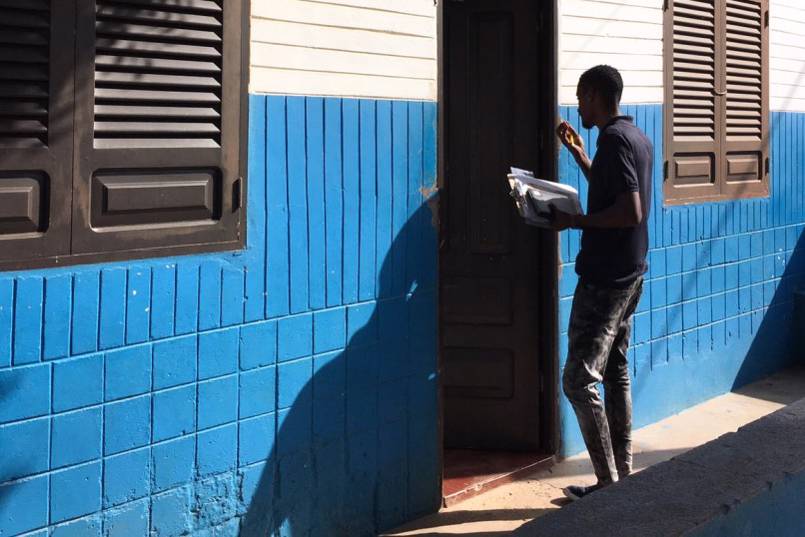 Field researcher Patrick knocks on a door during the MIGNEX pilot survey in Cabo Verde.