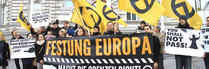 Far-right activists at an Identitarian Movement of Austria anti-immigration rally in Vienna. The German-language signs read 'Fortress Europe', 'Close the Borders Now!', 'My Home is Not an Immigrant Country', and 'Europe, Youth, Reconquista'. Wikimedia Commons
