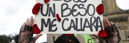 A woman holds up a poster dotted with rose petals and a message that reads in Spanish; “Only a kiss would shut me up,” during a march to protest physical abuse of women and in support of Colombia’s peace talks in Bogota, Colombia in 2013.
