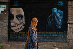 A woman walks past a mural calling for women and children's rights in Afghanistan on August 12, 2022 in Bamian, Afghanistan. Photo: Nava Jamshidi/Getty Images