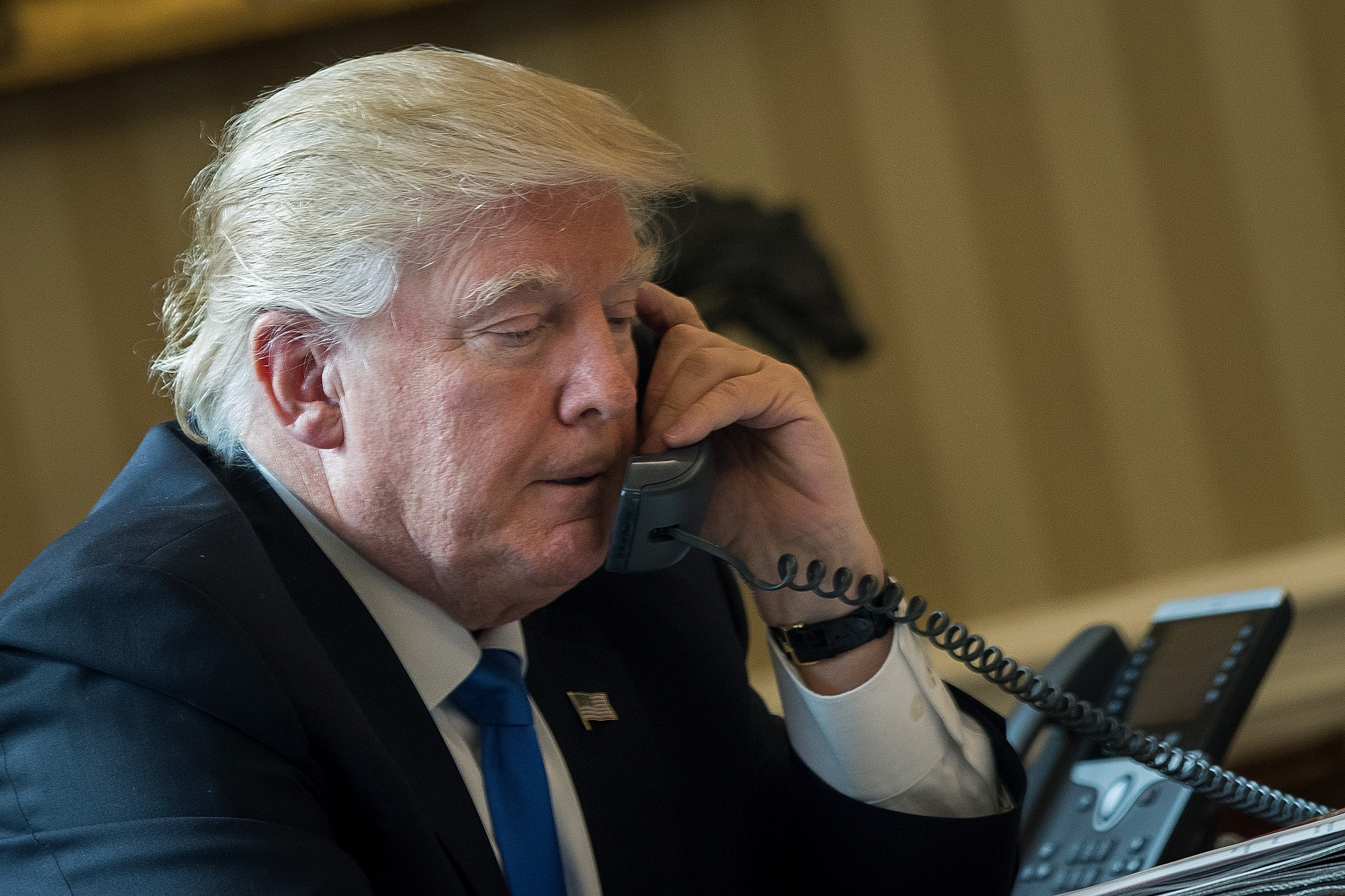 Donald Trump on the phone with Vladimir Putin. Photo: Drew Angerer/Getty Images