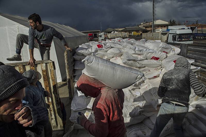 Turkish workers load bags of flour provided by the Turkish Red Crescent onto a truck bound for Syria, at the Turkish Syrian border, in Kilis, Turkey, February 11, 2013. Photo: Felton Davis CC BY