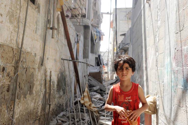 Photo: UN Photo/Shareef Sarhan. Palestinians inspect the remains of a house was targeted in an Israeli air strike, in beach refugee camp west Gaza City July 12, 2014.